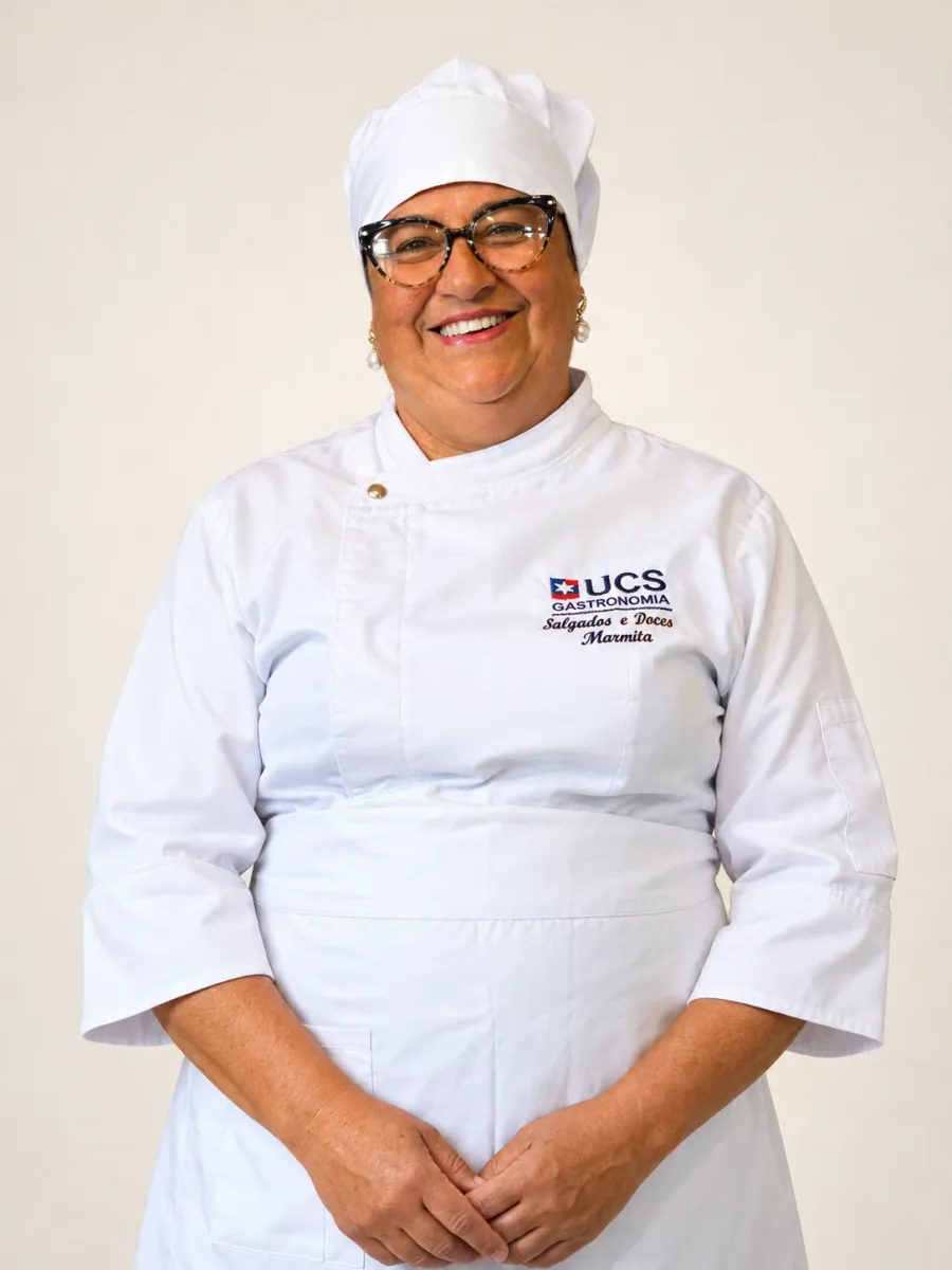 Jaqueline da Rosa sorrindo, de touca e dólmã brancos, com as mãos à frente